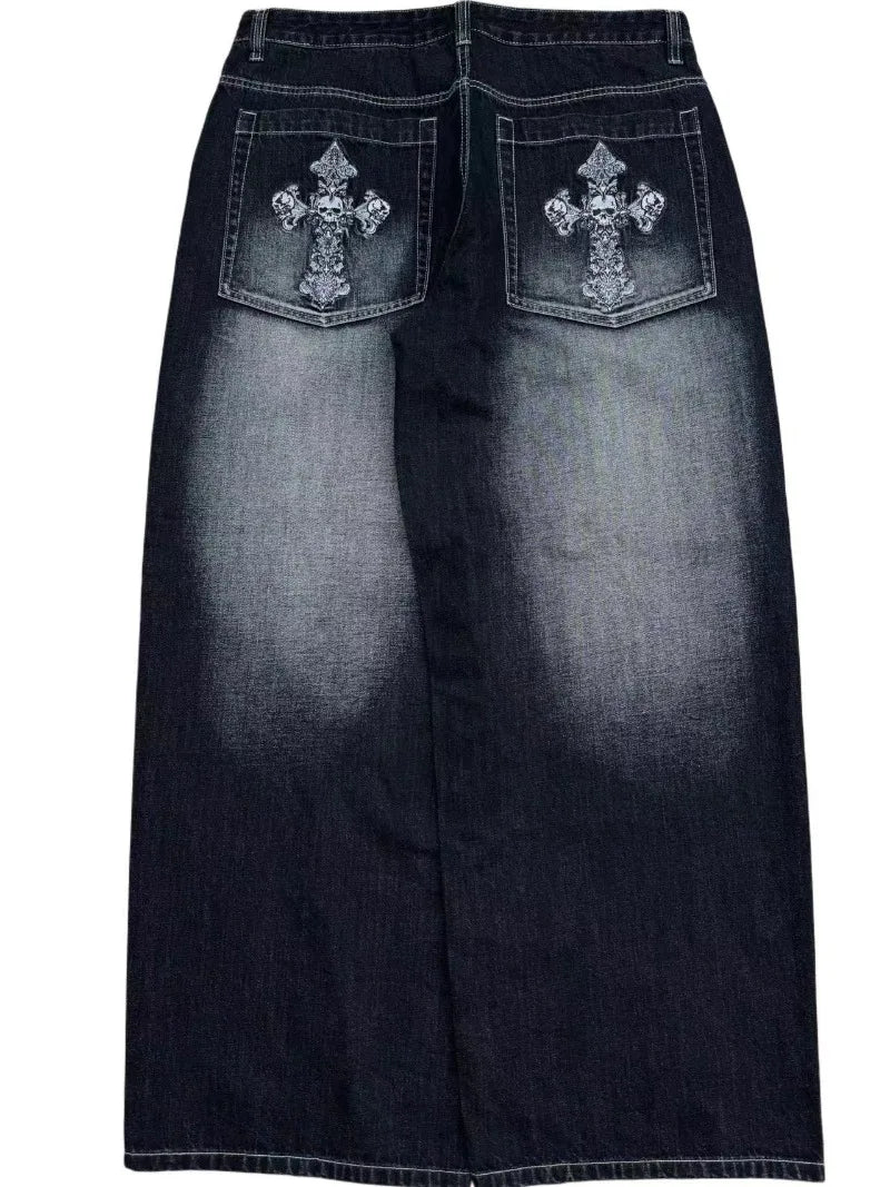 A pair of denim wide-leg jeans with embroidery on the back pockets, displaying a vintage wash effect.