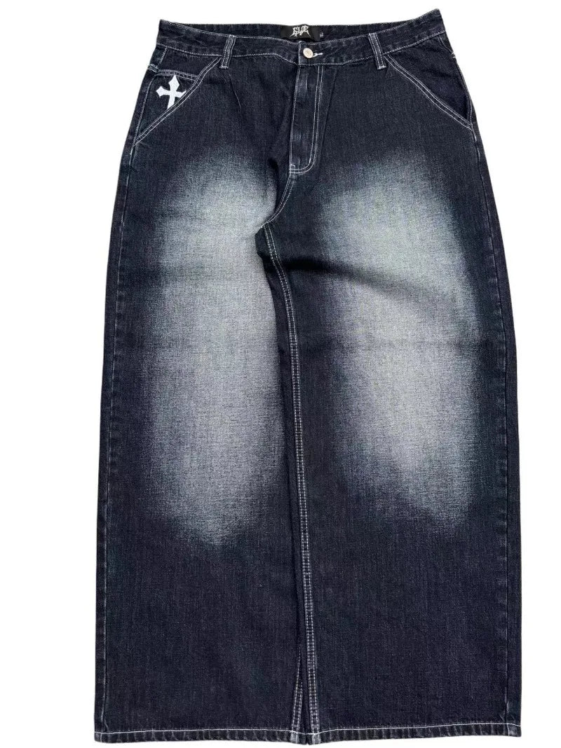 A pair of denim wide-leg jeans with embroidery on the back pockets, displaying a vintage wash effect.