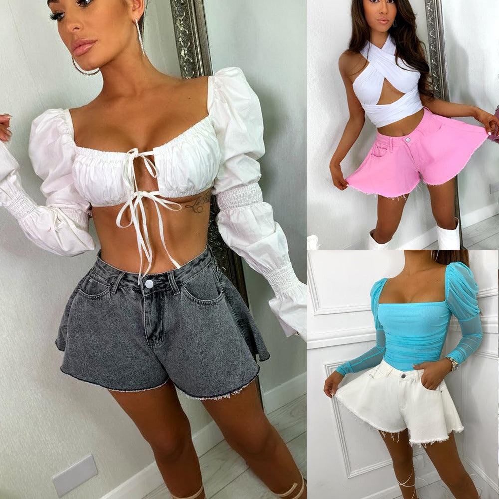 Three models wearing denim shorts in different colors: gray, black, and white. The shorts have a flared and frayed design.